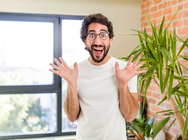 Foto jovem adulto louco com pose expressiva no interior de uma casa moderna