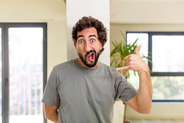 Foto jovem adulto louco com pose expressiva no interior de uma casa moderna