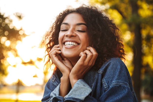 Jovem africana feliz em jaqueta jeans