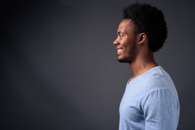 Jovem africano bonito contra um fundo cinza