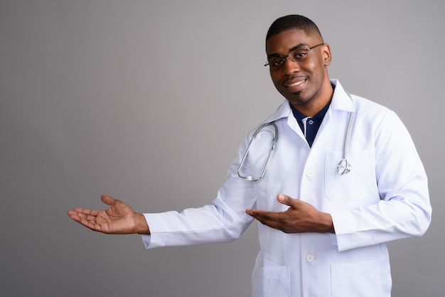 Jovem africano bonito médico em cinza