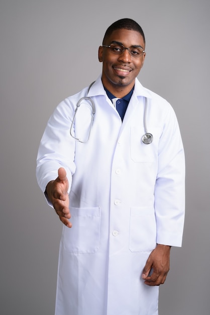 Jovem africano bonito médico em cinza