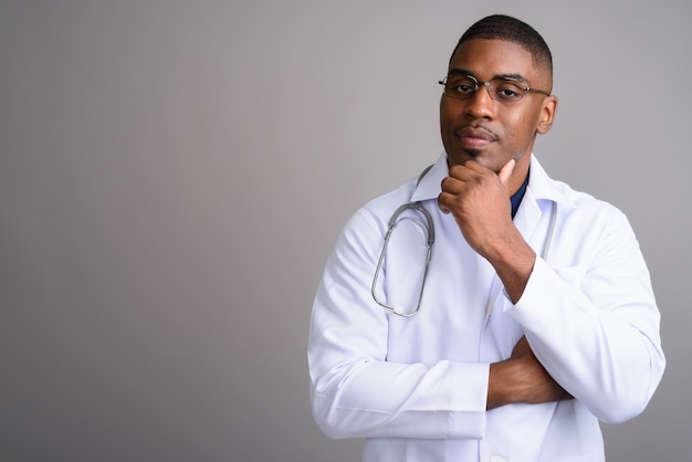 Jovem africano bonito médico em cinza