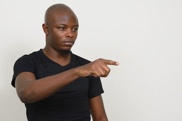 Jovem africano careca estressado apontando o dedo