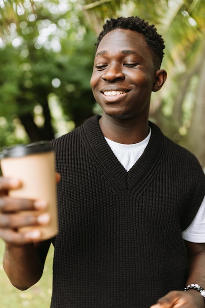 Jovem africano com uma xícara de café na rua ao ar livre