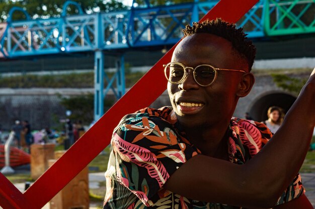 jovem africano feliz e relaxado sorrindo ao pôr do sol em um parque na Argentina