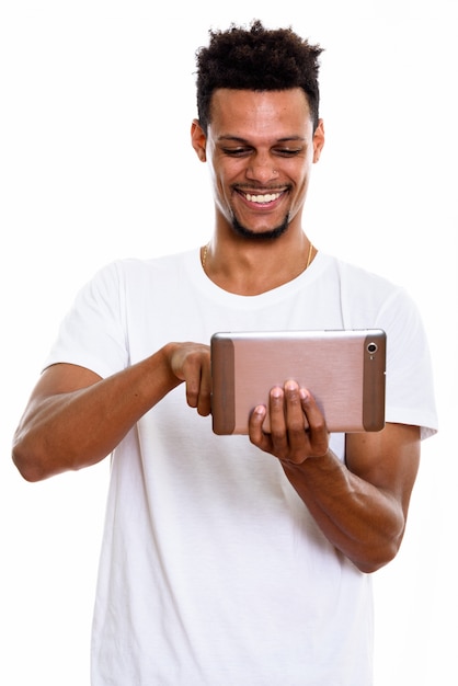 Jovem africano feliz sorrindo enquanto usa tablet digital