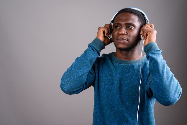 Jovem africano ouvindo música em cinza