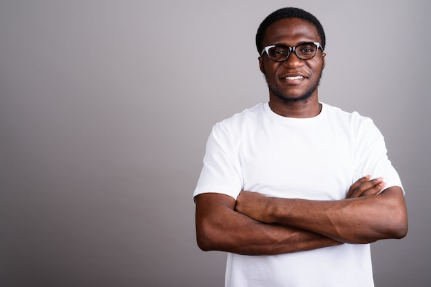 Jovem africano vestindo camisa branca e óculos cinza