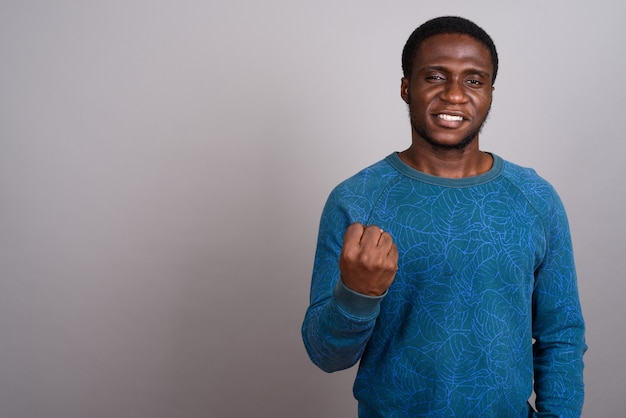 Jovem africano vestindo uma camisa azul de mangas compridas na cor cinza