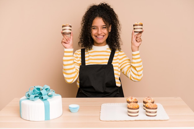 Jovem afro-americana aprendendo a fazer muffins e bolo doce