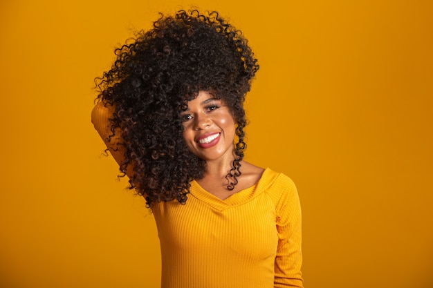 Jovem afro-americana com cabelos cacheados e sorrindo. linda garota afro com cabelo encaracolado sorrindo