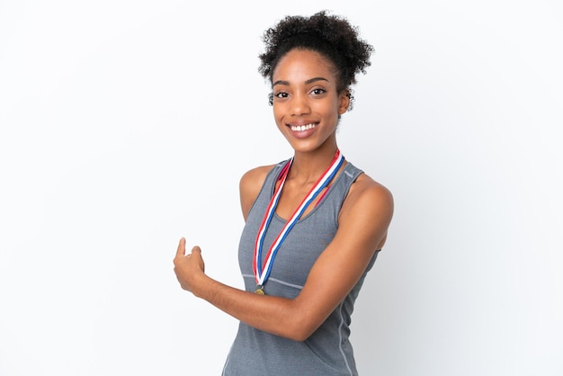 Jovem afro-americana com medalhas isoladas em um fundo branco apontando para trás