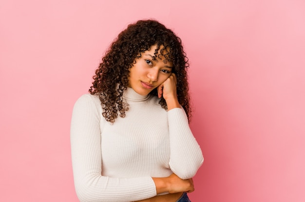 Jovem afro-americana isolada que se sente triste e pensativa, olhando para o espaço da cópia.