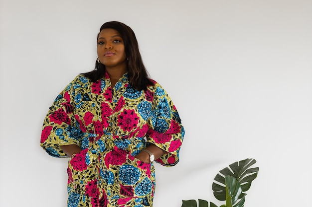 Foto jovem afro-americana usando vestido posando sobre parede branca em casa inclusão e espaço de cópia do conceito de diversidade e espaço vazio para texto ou publicidade