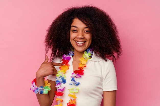 Jovem afro-americana vestindo uma pessoa havaiana apontando com a mão para um espaço de cópia de camisa, orgulhosa e confiante