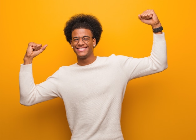 Jovem afro-americano em uma parede laranja que não se rende