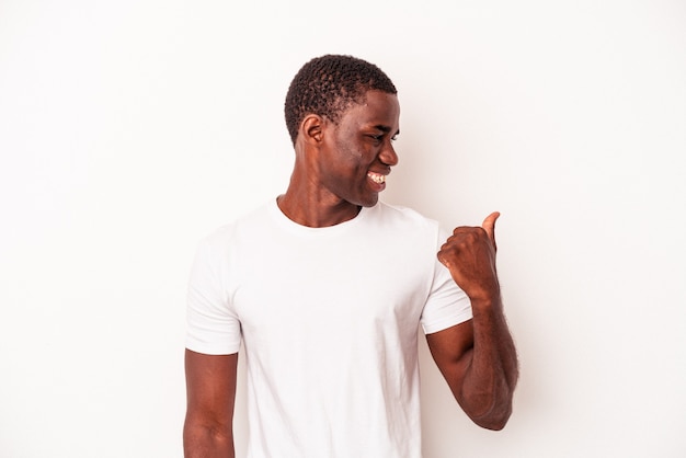 Jovem afro-americano isolado em pontos de fundo branco com o dedo polegar afastado, rindo e despreocupado.