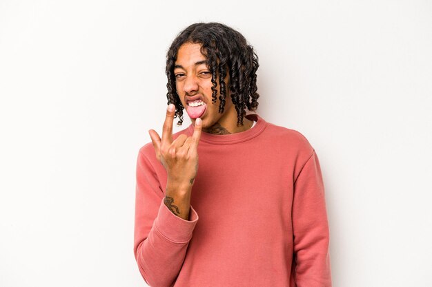 Jovem afro-americano isolado no fundo branco, mostrando o gesto de rock com os dedos