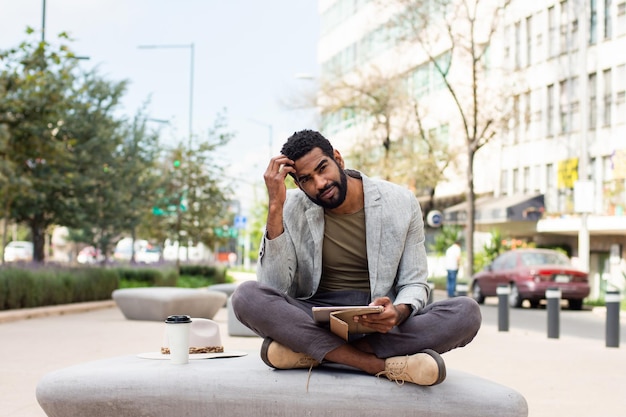 Jovem afro-americano na rua com um tablet