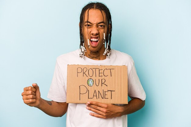 Jovem afro-americano segurando proteger nosso cartaz do planeta isolado em fundo azul