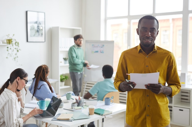 jovem afro-americano sorrindo com uma equipe de negócios multiétnica