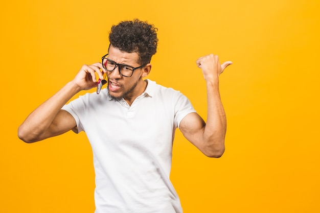 Jovem afro-americano usando smartphone estressado, chocado com vergonha e cara de surpresa