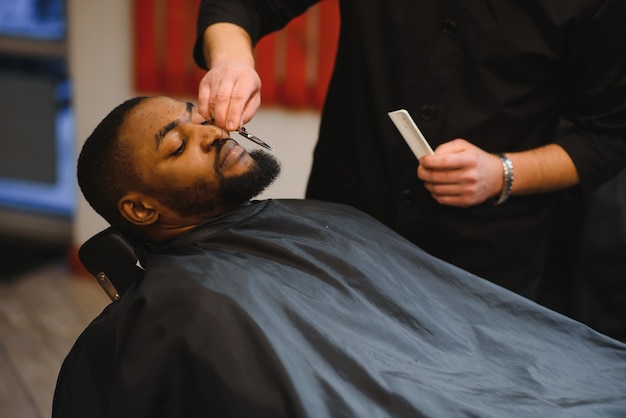 Jovem afro-americano visitando uma barbearia