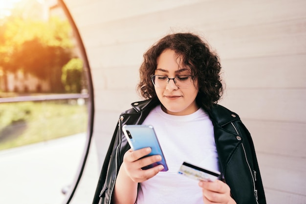 Jovem afro bonita usando telefone inteligente para negócios on-line, transferência de dinheiro, banco financeiro na internet