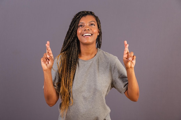 Jovem afro brasileira Dedos cruzados torcendo desejando loteria de sorte