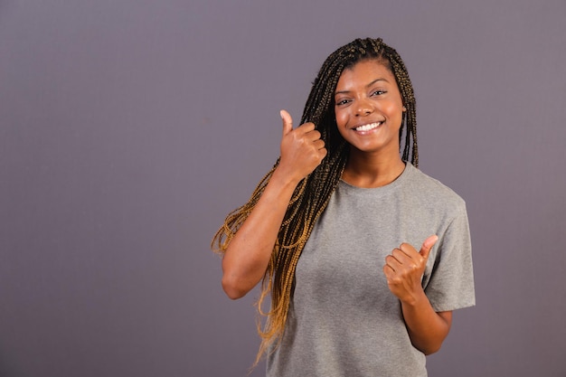 Foto jovem afro brasileira polegar para cima otimismo aprovação positiva ok como