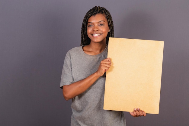 Jovem afro brasileira segurando placa para texto ou anúncio de foto de publicidade