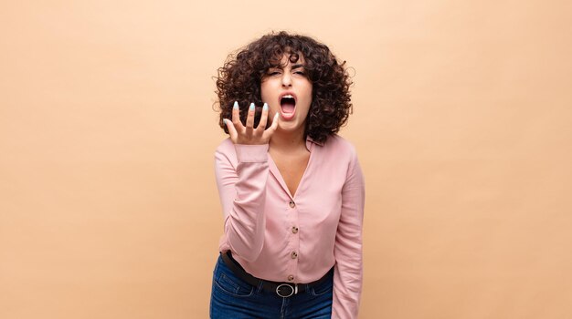 jovem afro contra parede de cor lisa