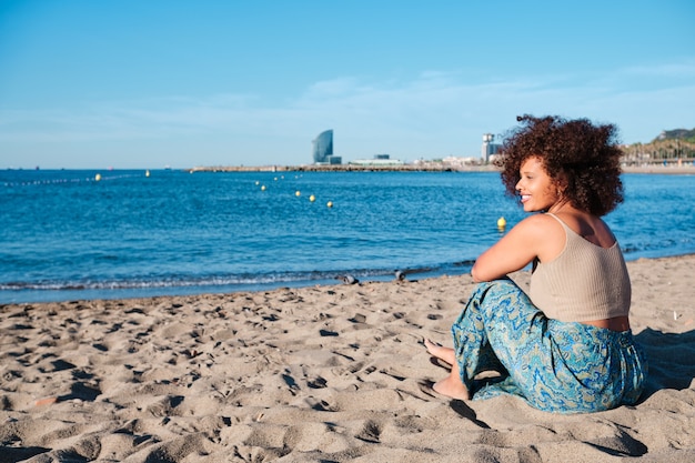 Jovem afro curvilínea na praia de Barcelona em um dia de verão