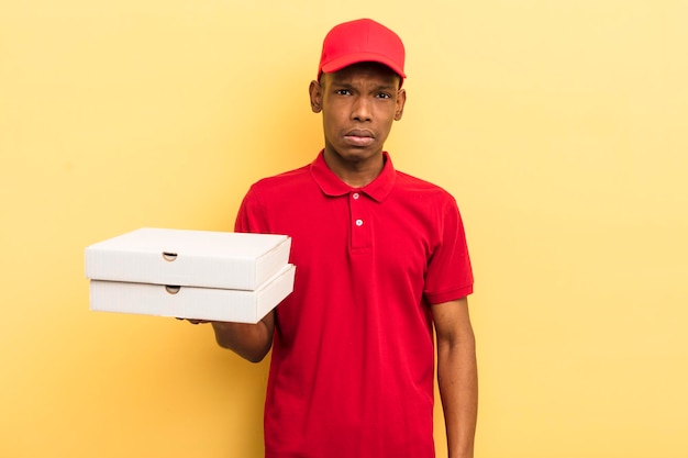 Jovem afro negro se sentindo confuso e confuso conceito de entregador de pizza