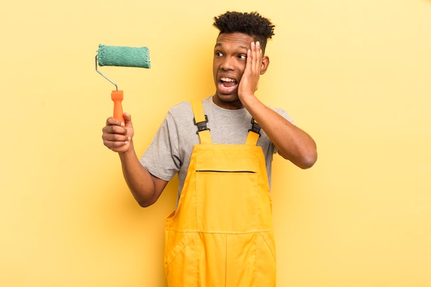 Jovem afro negro se sentindo feliz, animado e surpreso governanta pintando em casa