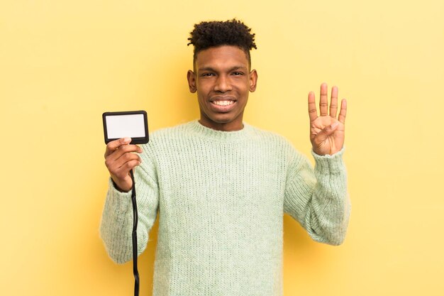 Jovem afro negro sorrindo e parecendo amigável mostrando o conceito de identificação de passagem de credenciamento número quatro