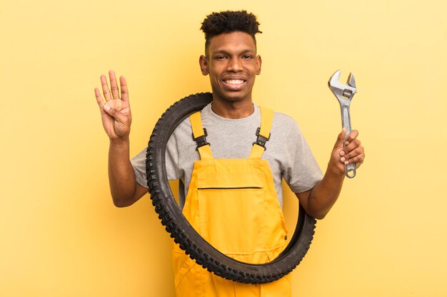 Jovem afro negro sorrindo e parecendo amigável mostrando o conceito mecânico de bicicleta número quatro