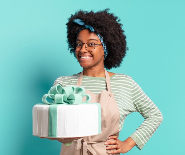 Jovem afro padeiro com um bolo de aniversário