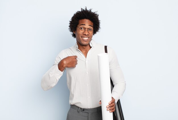 Jovem afro parecendo arrogante, bem-sucedido, positivo e orgulhoso, apontando para si mesmo