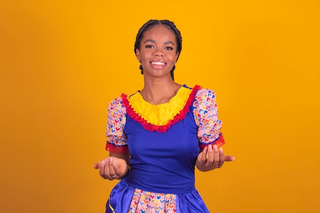 Jovem afro vestida com roupas típicas para festa junina