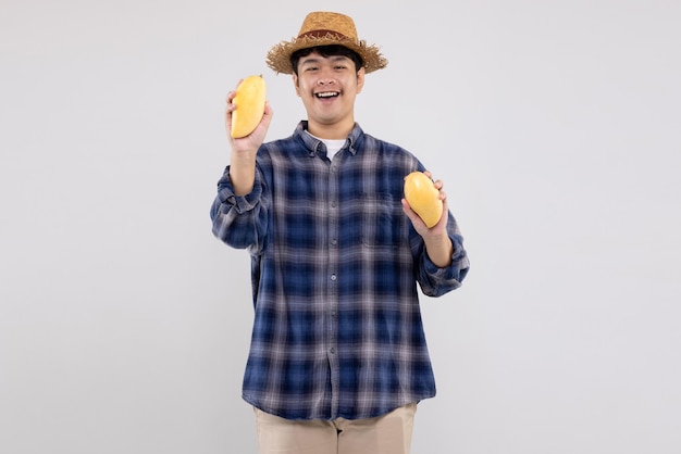 Jovem agricultor asiático mostra frutas de manga amarela orgânica em fundo branco