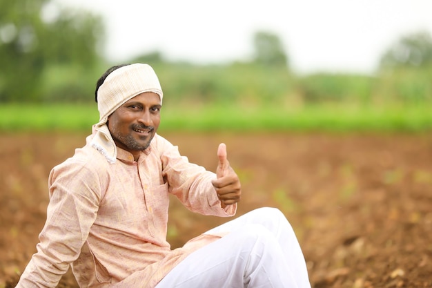Jovem agricultor indiano com roupa tradicional e aparecendo no campo.