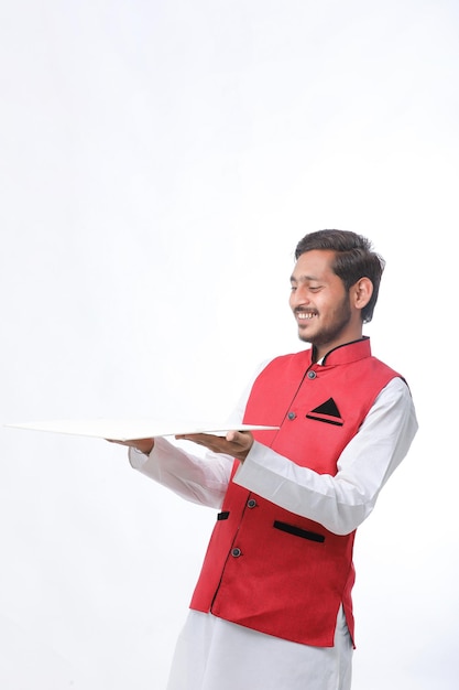 Jovem agricultor indiano em roupas tradicionais e dando expressão em fundo branco.