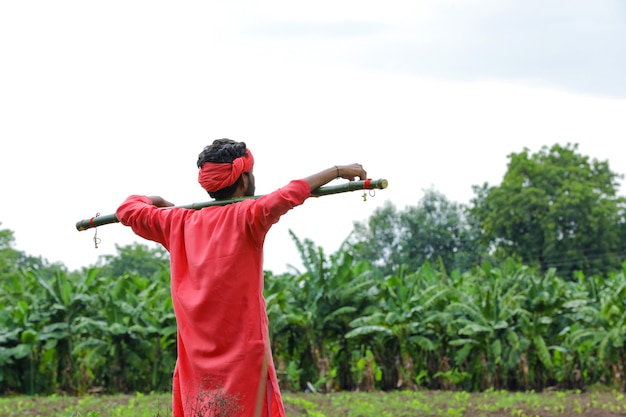 Jovem agricultor indiano em traje tradicional no campo