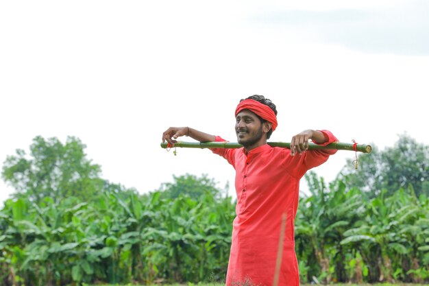 Jovem agricultor indiano em traje tradicional no campo