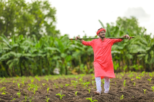 Jovem agricultor indiano em traje tradicional no campo