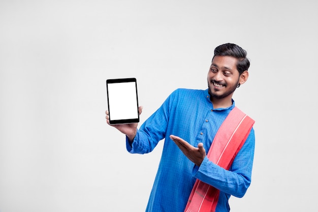 Jovem agricultor indiano mostrando o tablet e dando expressão em fundo branco.