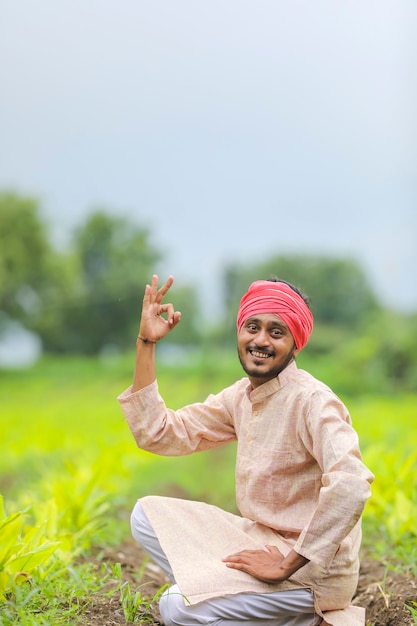 Jovem agricultor indiano no campo de agricultura de açafrão.