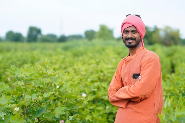 Jovem agricultor indiano no campo de agricultura de algodão